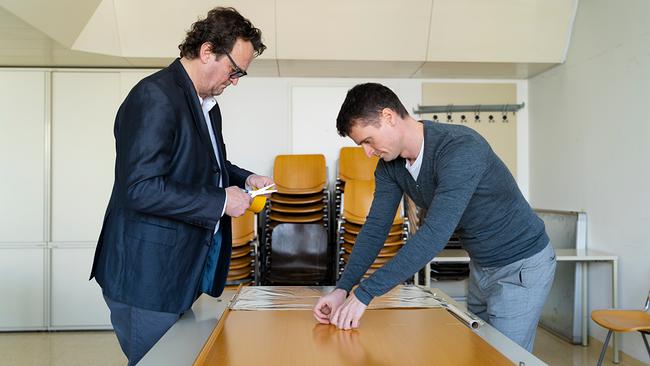 Hanno Settele steht gemeinsam mit einem Physikern der TU-Wien an einem Tisch und entwickelt einen Lifehack, der nur 1 Euro kostet, aber bis zu 200 Euro im Jahr sparen kann. Zu sehen ist Alufolie auf dem Tisch und Hanno hält eine Schere bereit.