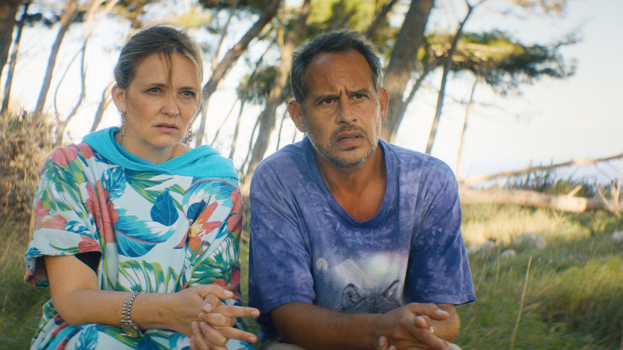 © ORF/ProSieben/LEONINE Studios Laura Tonke als Marion und Moritz Bleibtreu als Andi in bunter Sommerkleidung in einem Pinienwäldchen, beide blicken erstaunt drein