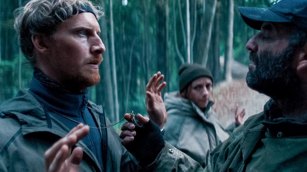 © ORF/Allegro Film In einem Wald steht Patrick mit erhobenen Händen einem Mann angespannt gegenüber, während Julia im Hintergrund ebenfalls die Hände hebt.