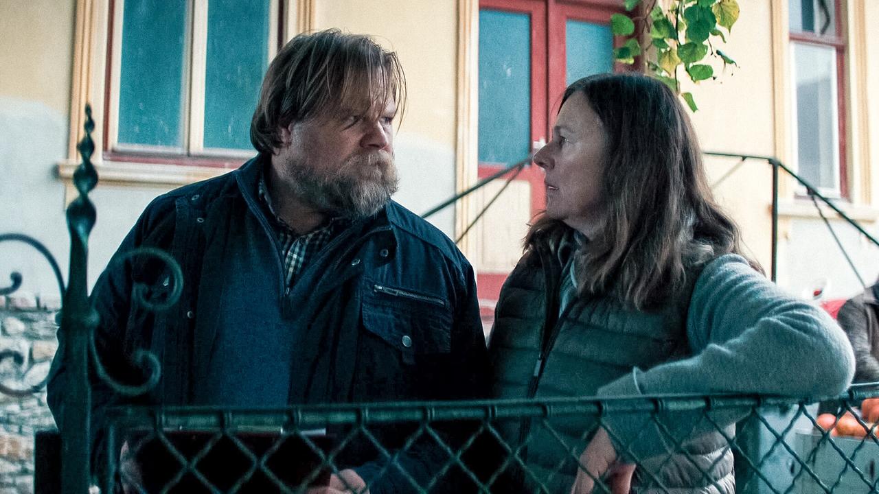 © ORF/Allegro Film Der bärtige Jens blickt ernst zu Carola. Beide stehen in einem von einem Geländer eingefassten Vorgarten.