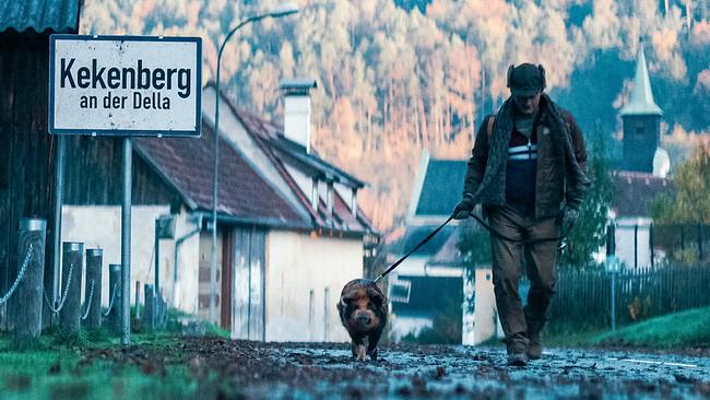 © ORF/Allegro Film Klaus geht mit seinem Schwein Schnitzi durch das regnerische Dorf „Kekenberg an der Della“.