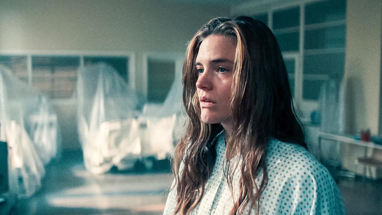 © ORF/Allegro Film Laura im Krankenhaushemd steht in einem hellen Krankenzimmer mit verhüllten Krankenbetten.