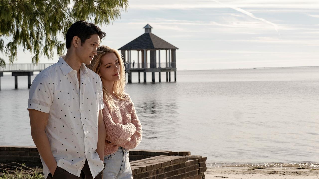 © ORF/Universal Ein junges Paar steht sommerlich bekleidet auf einem Sandstrand und blicken verträumt drein, hinter ihnen das Meer und ein Pavillon