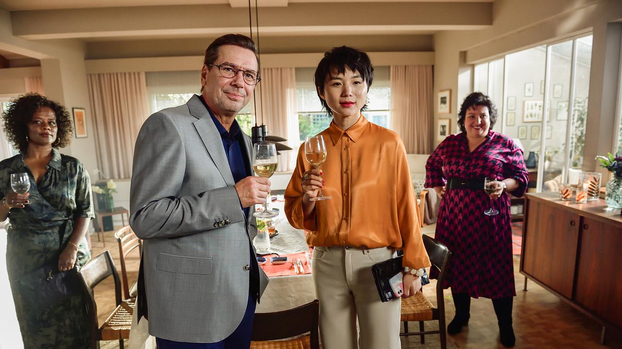 © ORF/LEONINE Studio/Wiedemann & Berg Film/Jürgen Olczyk Gäste beim gemeinsamen Essen im Wohnzimmer der Hellmichs: Dr. Joy Sand, Dr. Steinhofer, Lian Bell und Kiraz Tüfek stehen mit gefüllten Weingläsern um den Tisch
