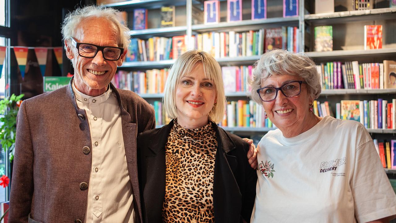 Gruppenfoto mit Herbert, Verena und Maria vor Bücherregalen in einer Buchhandlung in Wien