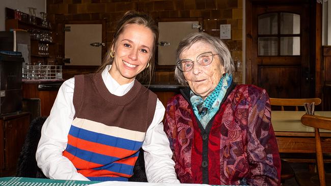 © ORF/Jenseide OG/Robert Oberzaucher Kira Schinko mit der 92-jährigen Wirtin „Mizi“ Ganglmair sitzen nebeneinander an einem Tisch in der Wirtshausstube.