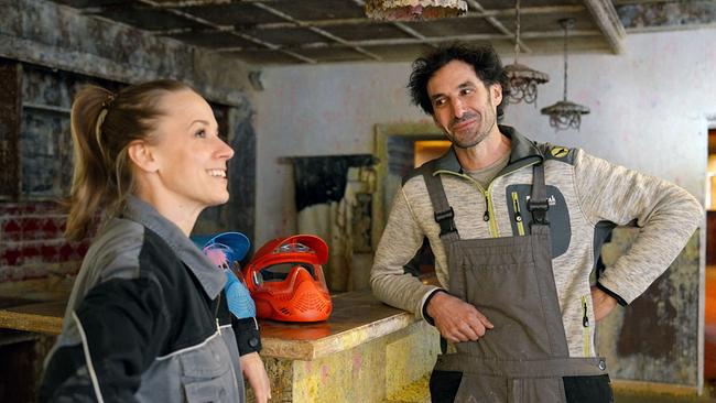 Kira Schinko steht mit Stefan Knappitsch an einer Holztheke des elterlichen Wirtshauses, das er zur Paintball Arena umfunktioniert hat.