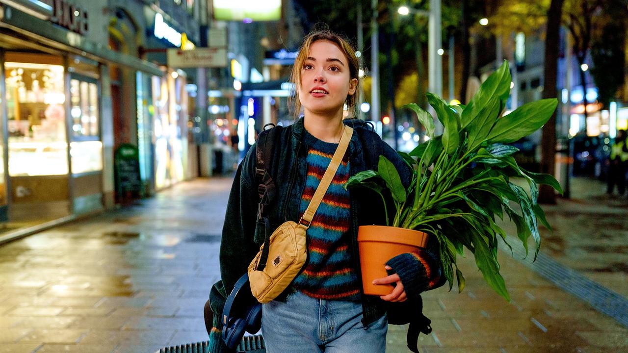 "Bis auf Weiteres unsterblich": Mara Romei (Marie) mit Trolley und Topfpflanze zu Fuß unterwegs in der Stadt