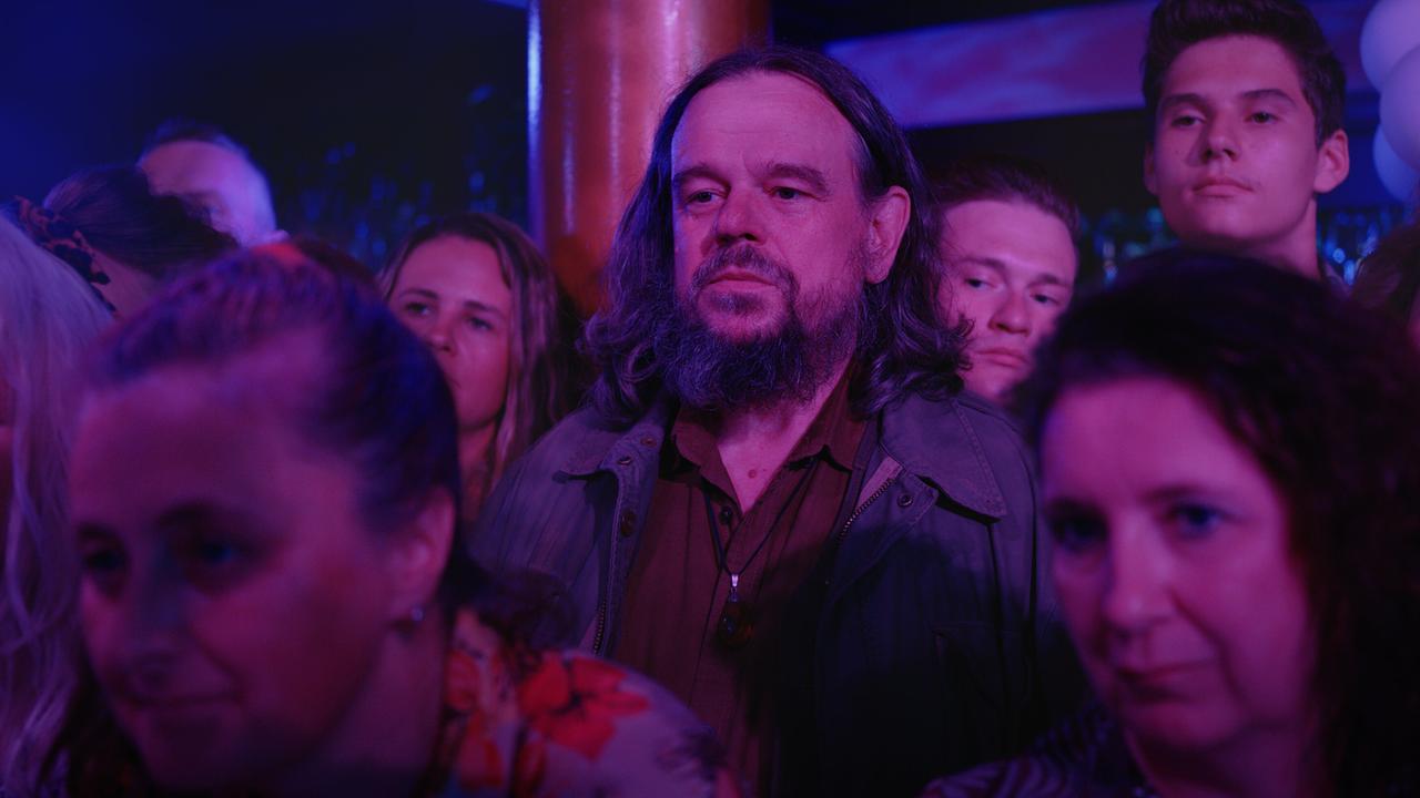 Reinhard Matussek steht dicht gedrängt in einer dunkel beleuchteten Clubatmosphäre zwischen weiteren Gästen.