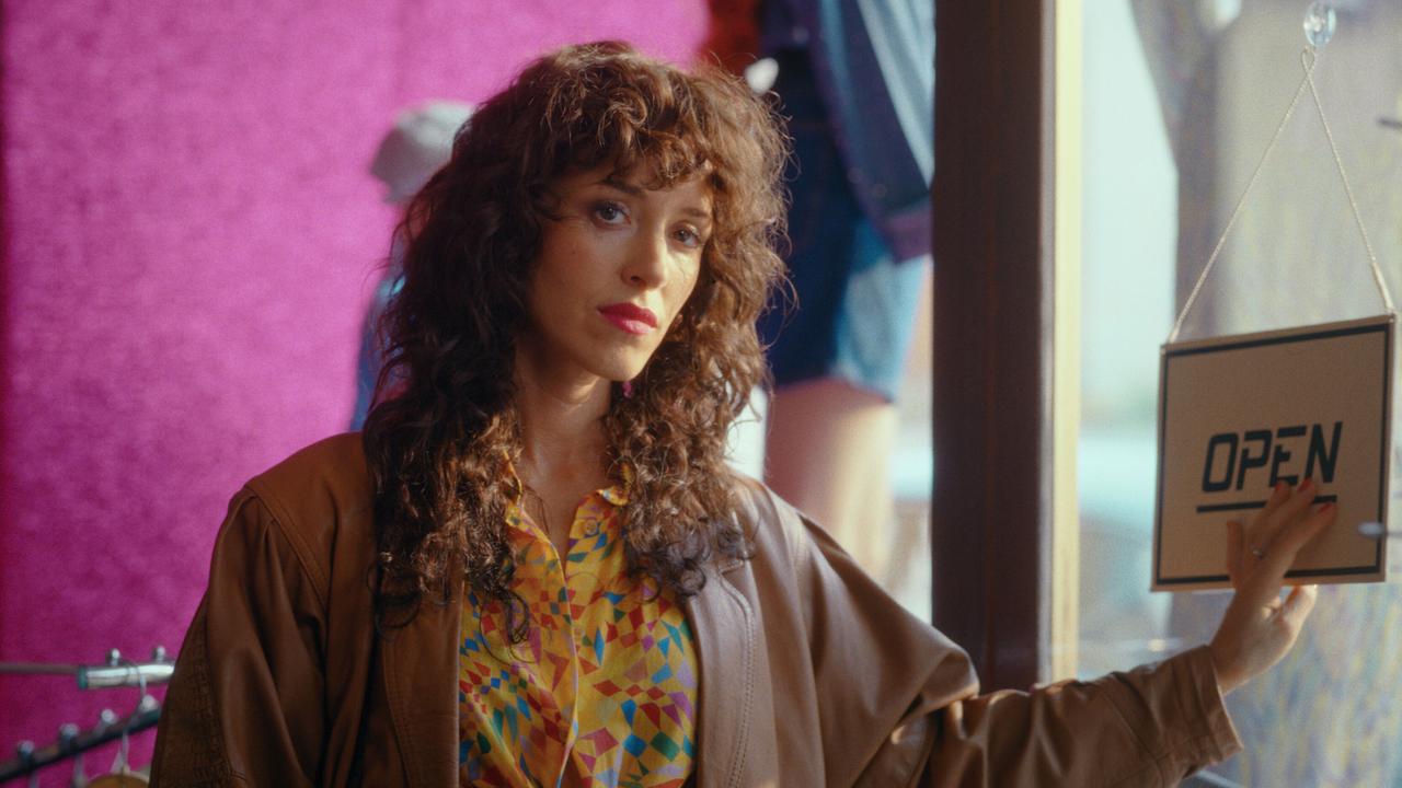 © ORF/Superfilm In einem Bekleidungsgeschäft steht Ronda bei der Eingangstür, neben ihr hängt ein „Open“-Schild.