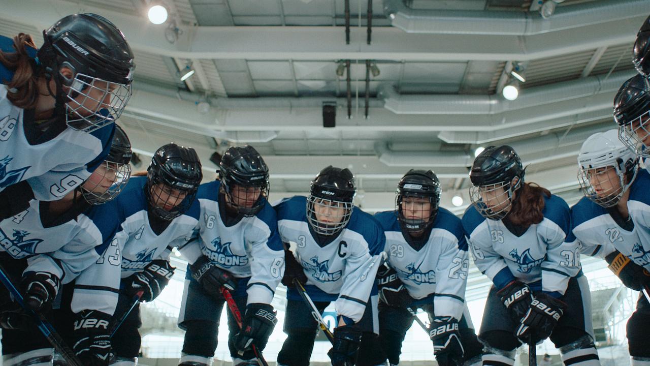 Ein Eishockeyteam steht im Kreis auf dem Eis.