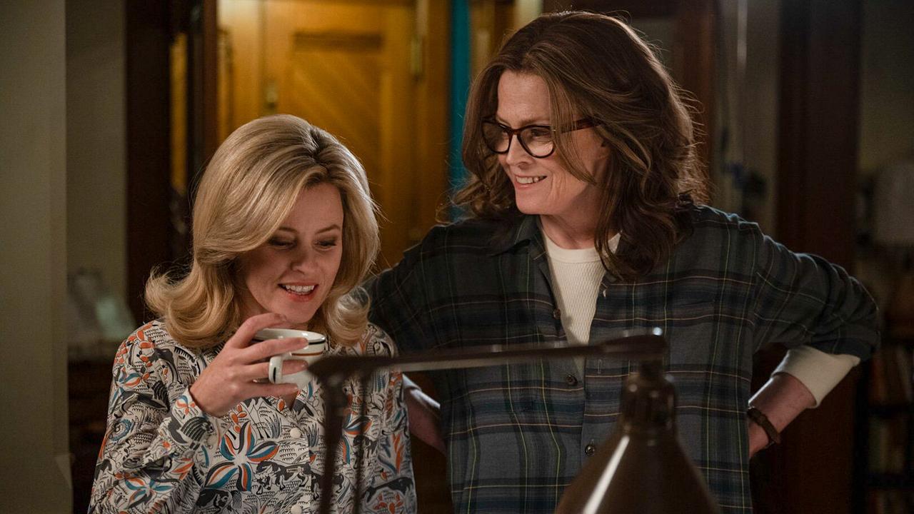 Elizabeth Banks als Joy in einer gemusterten Bluse hält eine Kaffetasse in ihrer Hand, neben ihr Sigourney Weaver als Virgina in weißem Shirt und dunklem, kariertem Flanellhemd