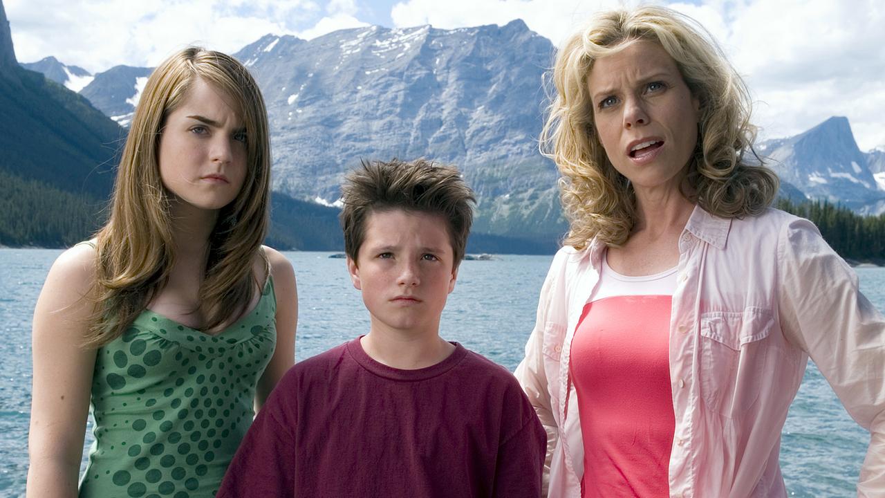© ORF/Sony Pictures/Joe Lederer Eine blondhaarige Frau steht mit ihrer Tochter und dem jüngeren Sohn in Freizeitkleidung vor einem großen See, dahinter imposante Bergkulisse