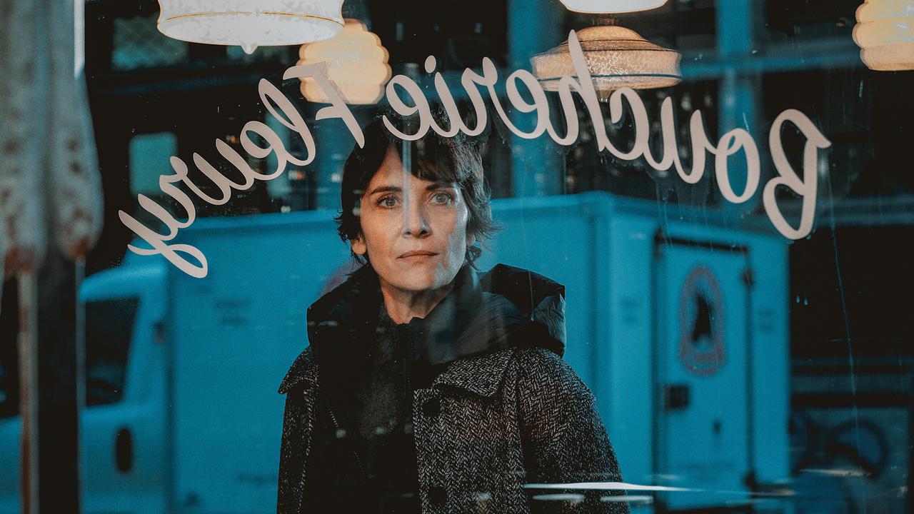© ORF/Vuelta Entertainment/Les Films du Cap/MM Films/Orange Studio/PIXELLEPHOTO Charly Fleury steht am Abend vor einer Fleischhauerei und blickt durch die Scheibe durch das beleuchtete Geschäft, spiegelverkehrt ist in Schreibschrift Boucherie Fleury zu lesen