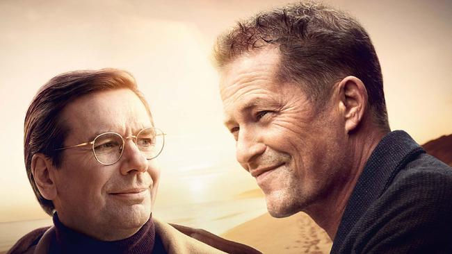 © ORF/ProSieben/Constantin Film Michael Maertens als Arthur mit Brille und Til Schweiger als Felix stehen nebeneinander, beide lächeln freundlich und blicken aneinander vorbei