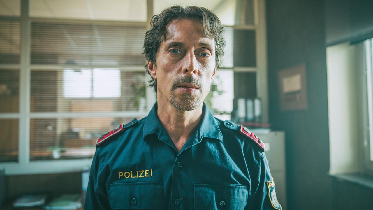 © ORF/ARD Degeto/Mona Film/Victoria Herbig Polizist Lukas steht in der Polizeidienstelle in Pias Büro.