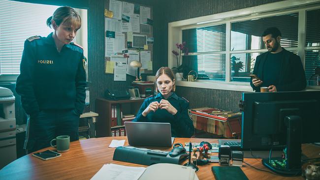 In der Polizeidienststelle: Polizistin Elli untersucht den Laptop des Lehrers Bichler. Pia und Tarek Moser stehen daneben und warten auf die Ergebnisse.