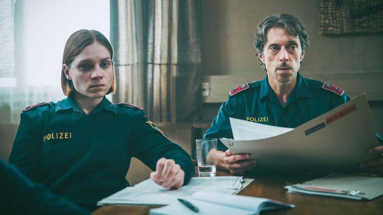 In der Polizeidienststelle nach der Sichtung eines Videos von Amelie: Die Polizisten Elli und Lukas verfolgen die Diskussion der anderen über verschiedene Theorien.