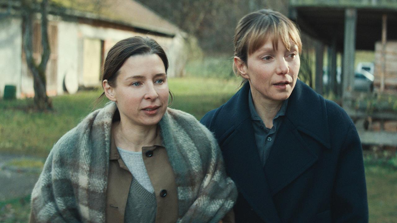 © ORF/ARD Degeto/Mona Film Caro und Pia stehen im Freien vor einem ländlichen Haus und unterhalten sich über ihre Kindheit.