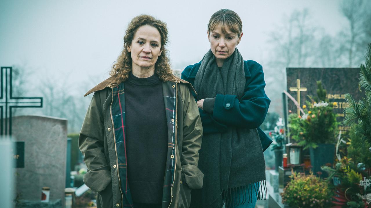 Anni Rath und Pia stehen am Grab von Annis Kind.