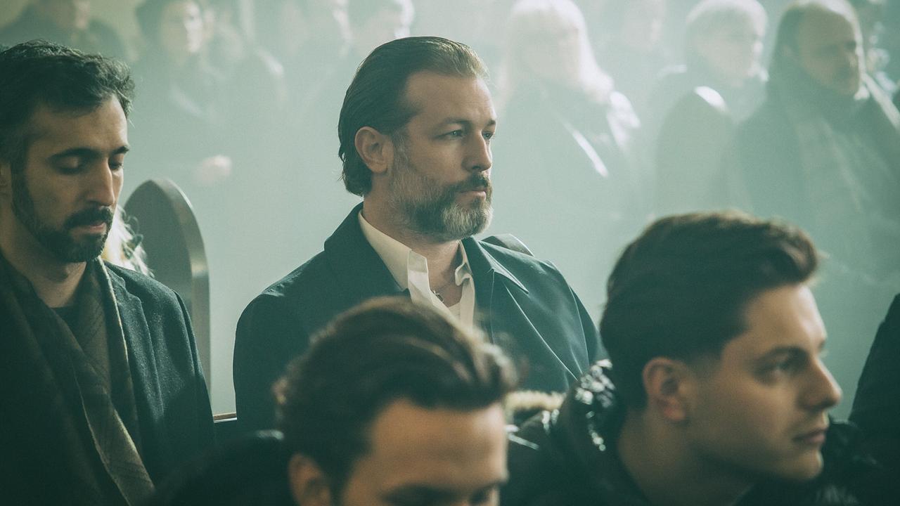 Andreas Broszek sitzt in der Kirche neben weiteren Trauergästen, bei der Trauerfeier für Amelie.