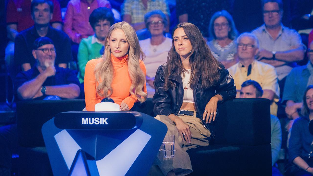 © ORF/ZDF/Thomas Kierok Melissa Naschenweng und Vanessa Mai sitzen am Pult der Kategorie „Musik“ vor dem Studiopublikum bei "Der Quiz Champion"