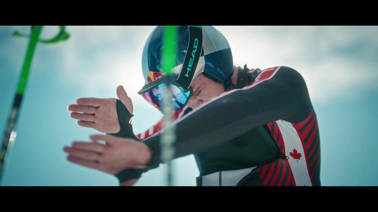 James Crawford, Weltmeister Super G und Streif-Sieger 2025, im Rennanzug und mit Helm führt vor dem Start fokussierte Armbewegungen aus.