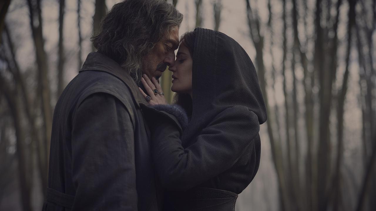 © ORF/Constantin Film Ein Mann mit zerzaustem Haar und Bart steht eng umschlungen mit einer Frau in dunkler Kapuze im Wald, in einer stimmungsvollen, intimen Szene