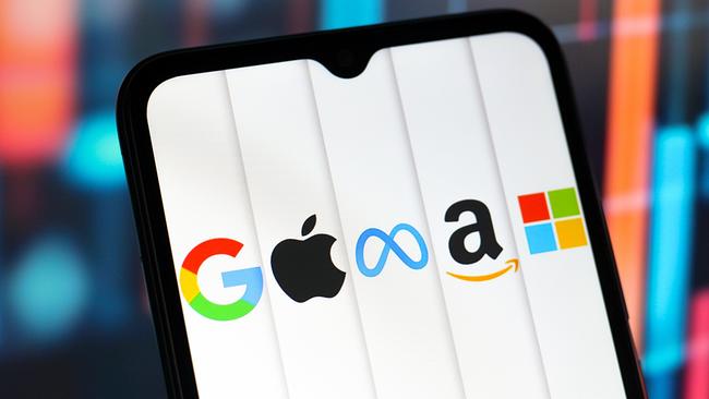 Auf dem Display eines Handys sind die Logos von Google, Apple, Meta, Amazon und Microsoft zu sehen