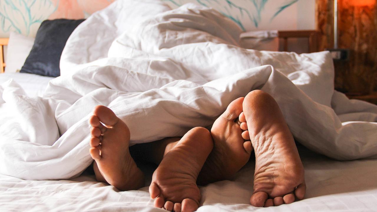 © ORF/RTL/WildBear Entertainment/PBS International/Shutterstock/AimPix Zwei Personen engverschlungen unter einer weißen Decke in einem Bett, nur ihre Fußsohlen schauen unter der Decke hervor