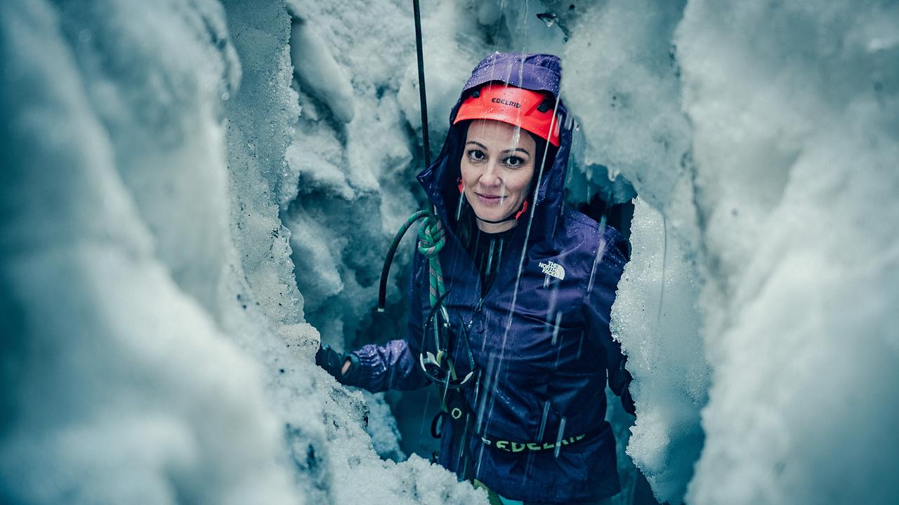 Dok 1: Lisa Gadenstätter in einer Gletscherspalte am Jamtal-Gletscher. Mehrere Meter ober ihr bauen Bergretter gerade eine Vorrichtung auf, um die Journalistin aus der Gletscherspalte zu ziehen. Für Lisa ist der Gedanke, ohne Sicherung in eine Gletscherspalte zu stürzen, beängstigend. Für Bergretter und Bergretterinnen sind solche Einsätze eine große Herausforderung, wie Lisa im Laufe ihrer DOK1 erfahren wird.