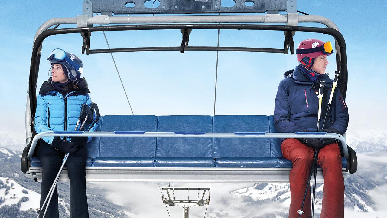 © ORF/Disney/20th Century Studios Auf einem 5er-Sessellift sitzt eine Frau im blau-schwarzem Skiausrüstung ganz links, ein Mann in blau-roter Skiausrüstung ganz rechts - beide blicken zur Seite voneinander weg