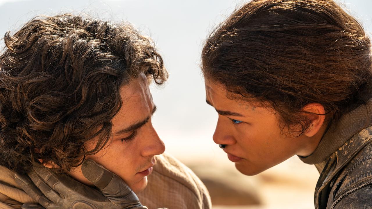 Timothée Chalamet als Paul Atreides und Zendaya als Chani schauen einander tief in die Augen, mit ihrer Hand hält sie sanft seine Wange 