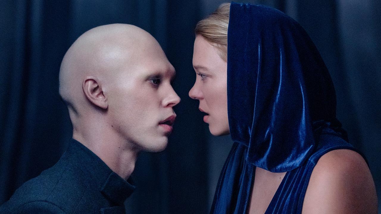  Austin Butler unterhält sich als kahlköpfiger Feyd-Rautha mit Léa Seydoux als Lady Margot in einem blauem Kleid mit einem blauen Tuch über ihrem Kopf