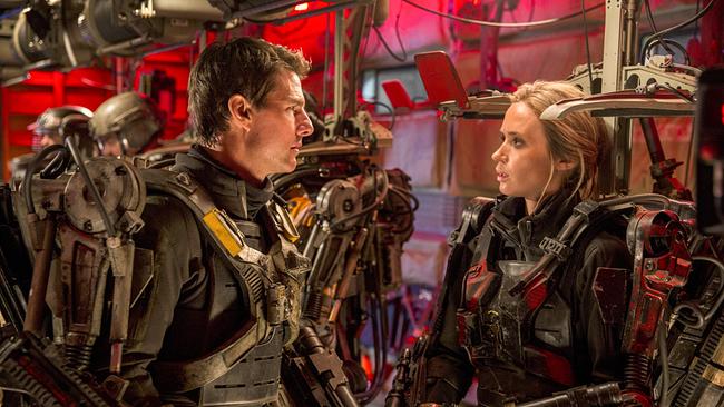 © ORF/Warner Bros. Pictures Tom Cruise als Major Bill Cage und Emily Blunt als Rita Vrataski tragen Exoskelette und stehen sich gegenüber und schauen sich ernst an