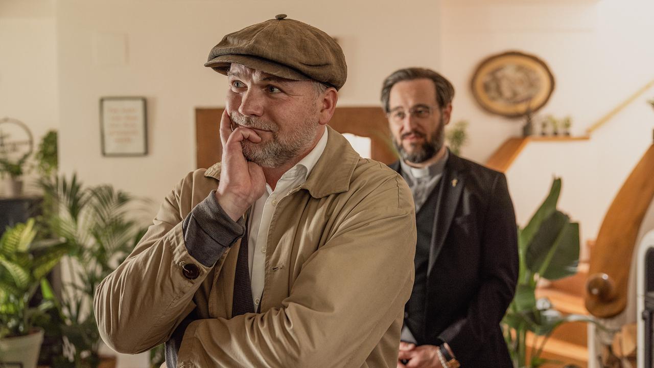 Der nachdenklich schauende Sifkovits und David Grandits stehen in einem hellen Raum umgeben von Grünpflanzen.