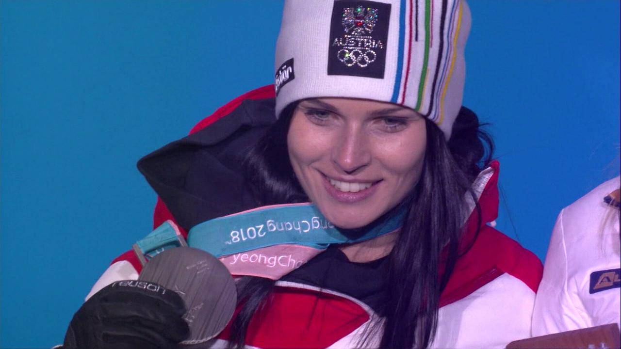 © ORF/ORF Sport Anna Veith zeigt ihre olympische Silbermedaille bei einer Siegerehrung.