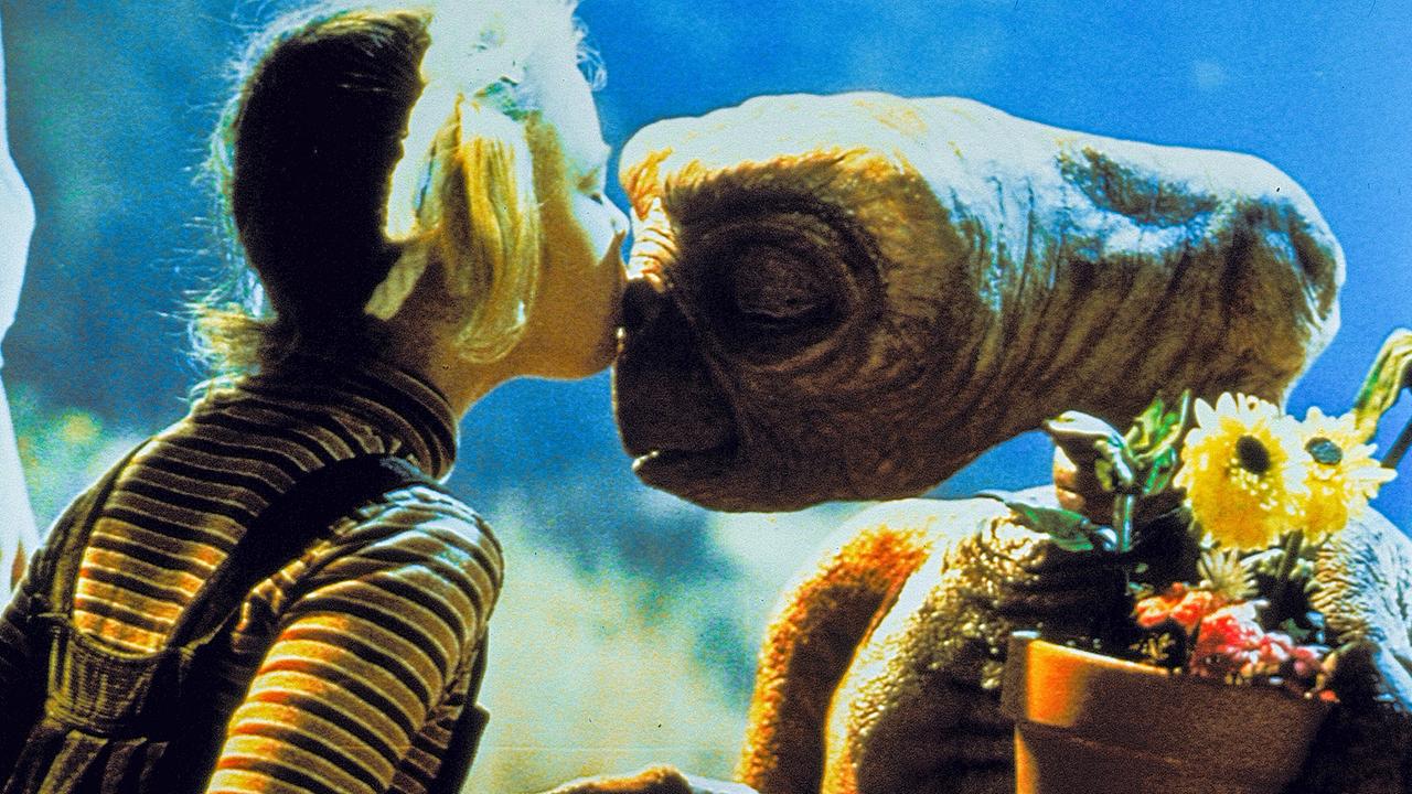 Drew Barrymore gibt als Gertie dem Außerirdischen E.T. ein Küsschen, dieser hält einen Blumentopf im Arm 