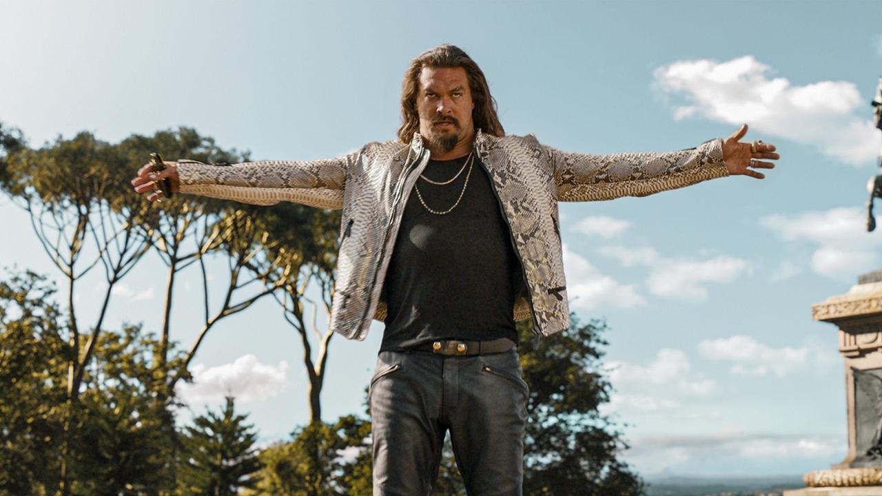 © ORF/Universal Pictures Jason Momoa als Dante breitet seine Arme weit auseinander und blickt drohend nach vorne, über einem schwarzen T-Shirt und grauer Hose trägt er eine weiß-graue Jacke aus Schlangenleder