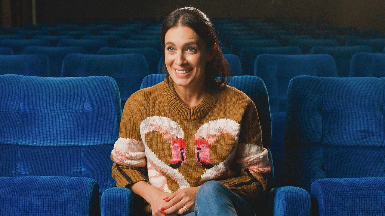 Doris Golpashin beim Interview  in einem leeren Kinosaal auf einem blauen Sessel