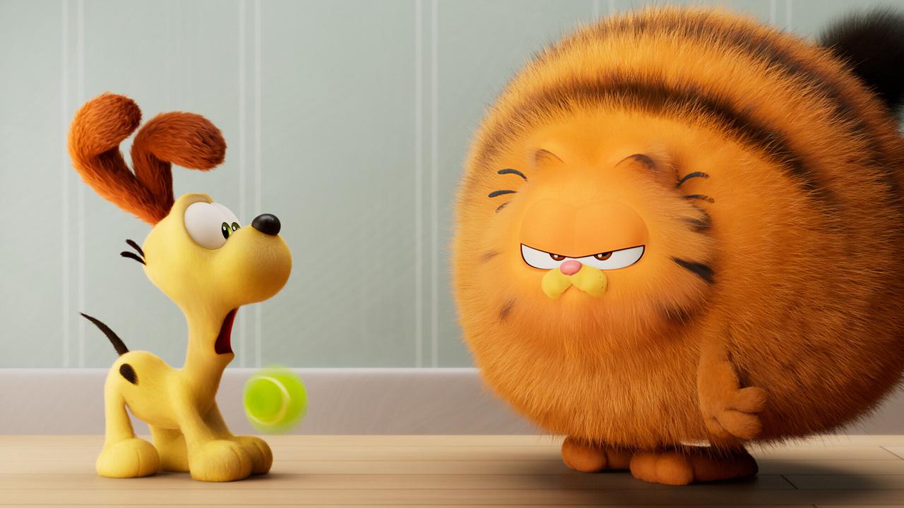 © ORF/Sony Pictures Der cremefarbene Odie lässt erschrocken den Tennisball fallen, vor ihm steht ein vor einem riesigen, orangefarbenen Garfield, dessen Fell aufgebauscht ist