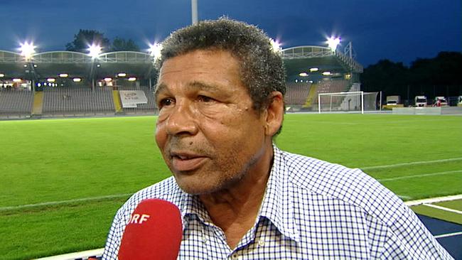 Helmut Köglberger steht beim Interview am Rand eines beleuchteten Fußballplatzes
