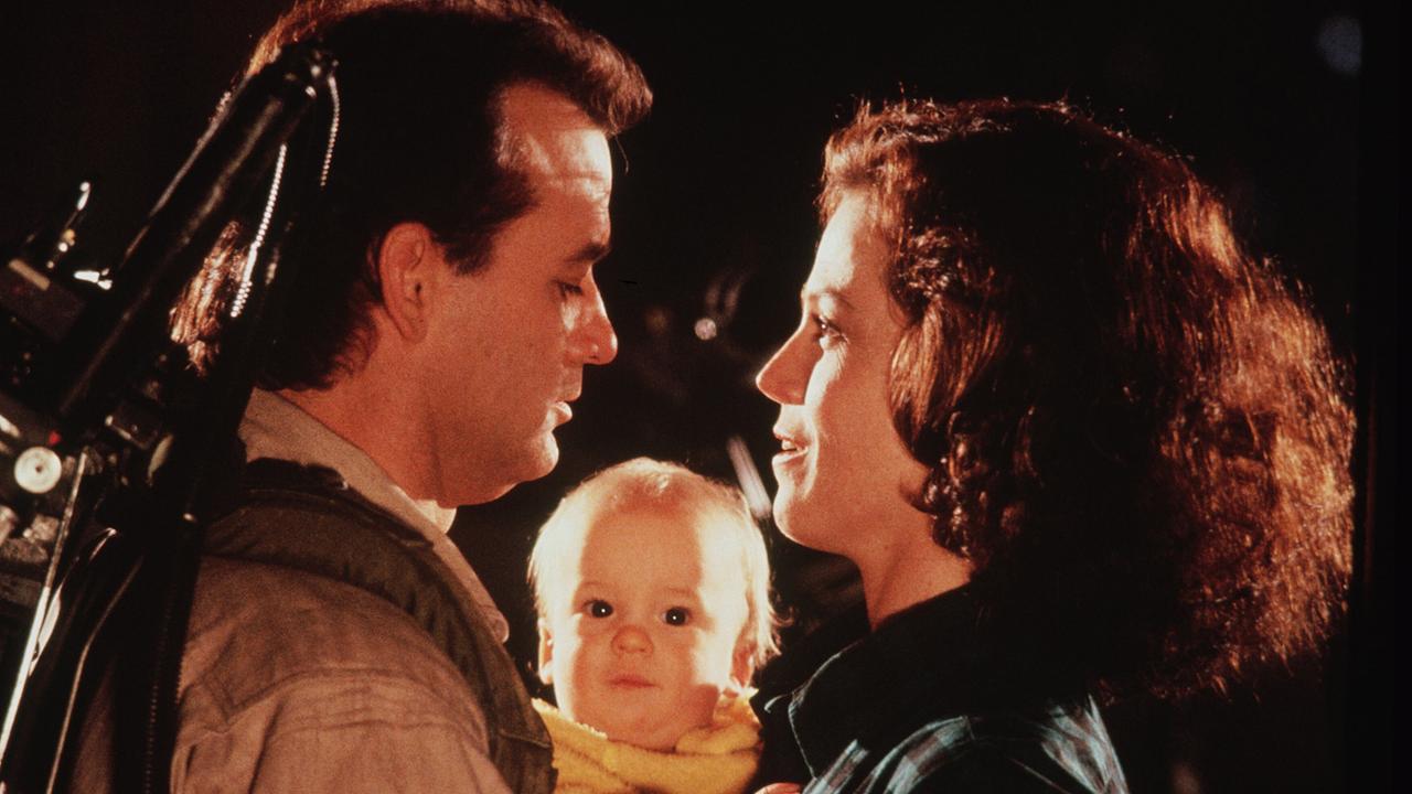 Bill Murray als Dr. Venkman in seiner Geisterjäger-Uniform und Sigourney Weaver als Dana Barrett stehen sich eng gegenüber, zwischen ihnen blickt ein Baby hervor, das sie im Arm hält