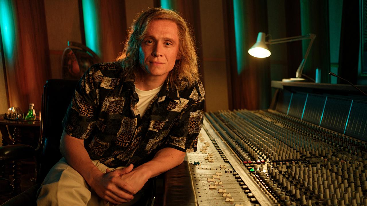 © ORF/Pro7/Leonine Studios/Wiedemann & Berg Film/Gordon Timpen Matthias Schweighöfer als Musikproduzent Frank Farian, der mit langen Haaren und stark gemusterten Hemd im Aufnahmestudio am Mischpult lehnt