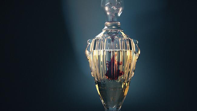 Ein aufwändig gestaletes Parfum-Fläschchen, vor schwarzem Hintergrund hell beleuchtet strahlt die Flüssigkeit im geschliffenem Glas