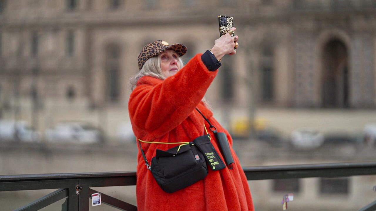 Die Französin Caroline Ida mit 64  macht als Influenceuse Silver ein Selfie von sich, in auffälolig rotem Wintermantel, mit Kappe in Geparden-Print