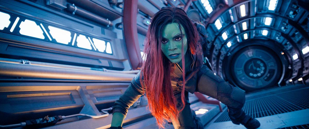 © ORF/Disney/© 2023 MARVEL Eine Frau mit grünem Gesicht, blauen Lippen, dunklen Augen und langen roten Haaren kämpft sich durch einen Transportraum eines Raumschiffes