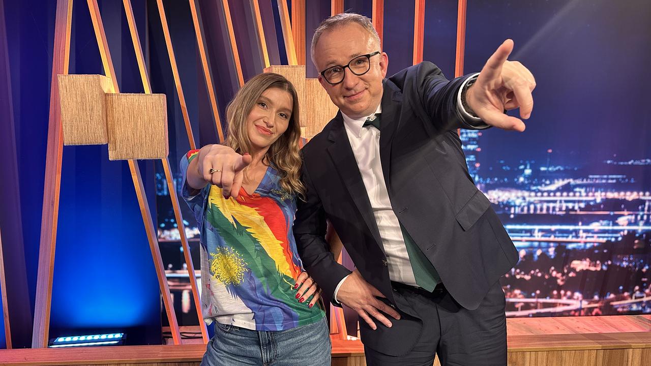 © ORF/Gebhardt Productions Malarina und Peter Klien posieren gut gelaunt im "Gute Nacht Österreich"-Studio und zeigen direkt in die Kamera.