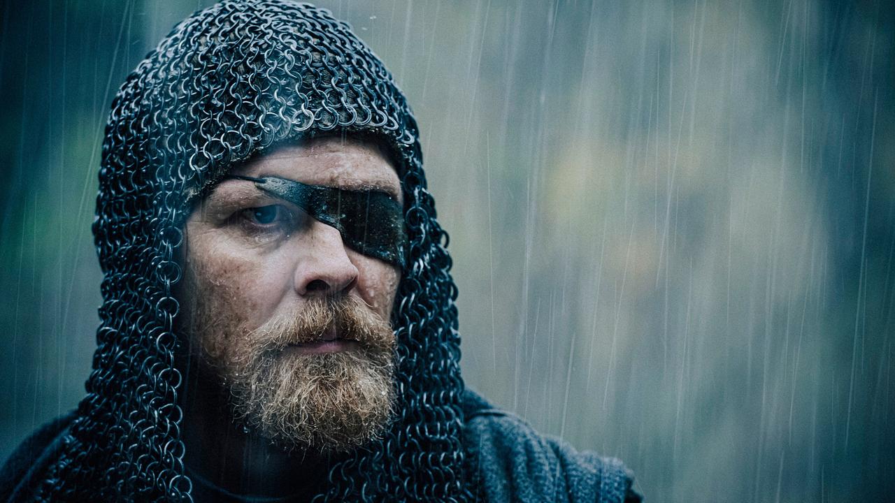 © ORF/Constantin Film/Stanislav Honzik Großaufnahme von Gijs Naber als bärtiger Hagen von Tronje mit mittelaltericher Kettenhaube und Augenklappe, im Regen blickt er ernst
