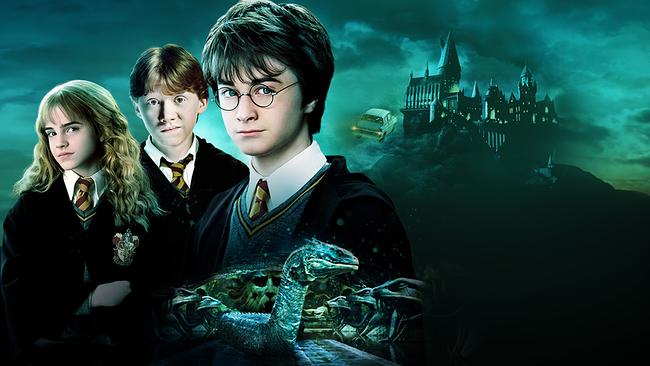 Hermine Granger, Ron Weasley und Harry Potter in den Uniformen ihrer Zauberschule, im Hintergrund Auto, das Richtung Hogwarts fliegt